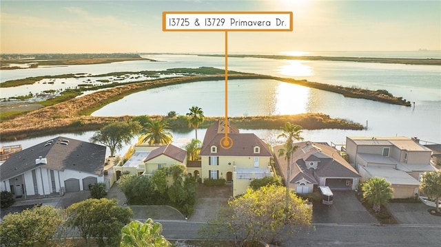 aerial view at dusk featuring a water view