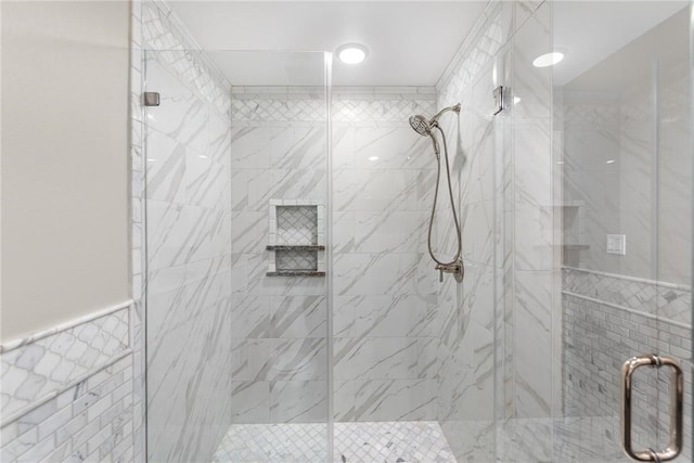 bathroom featuring an enclosed shower and tile walls