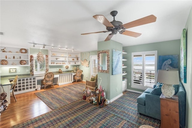 living room with ceiling fan, wood-type flooring, and track lighting