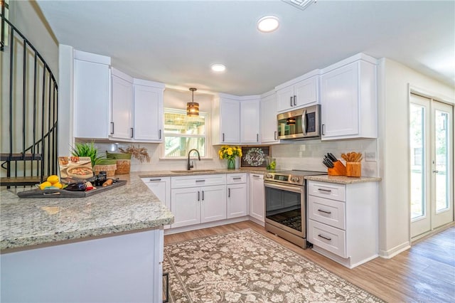 2322 Violet, Corpus Christi, TX 78410 - kitchen with stainless steel appliances, a sink, white cabinets, light wood finished floors, and recessed lighting