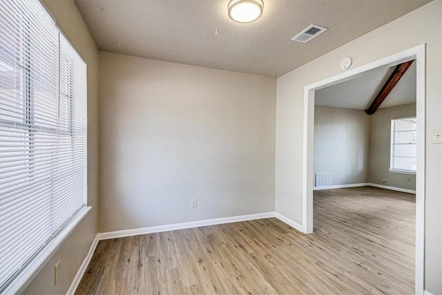 4113 Sierra St, Corpus Christi, TX 78410 - empty room with light wood-type flooring, baseboards, a smoke detector, and beamed ceiling