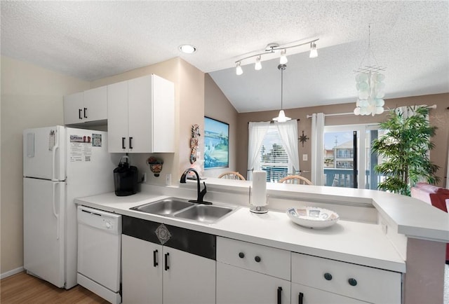 kitchen featuring sink, white cabinetry, decorative light fixtures, vaulted ceiling, and white appliances