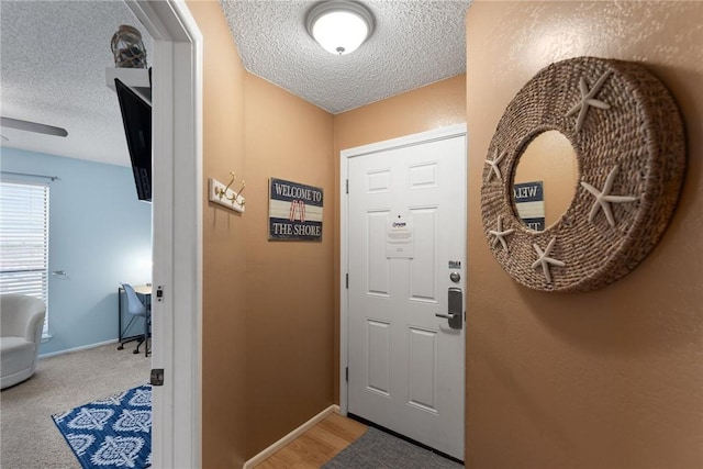 entryway featuring carpet floors and a textured ceiling