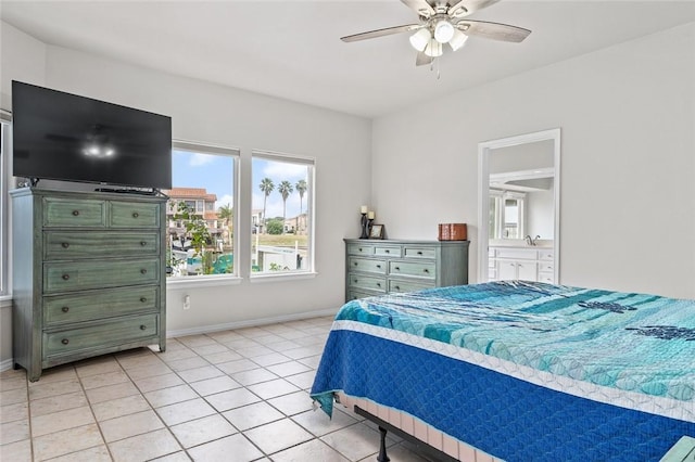 bedroom with ceiling fan, baseboards, ensuite bathroom, and light tile patterned flooring