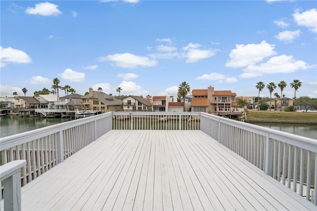 wooden terrace with a water view and a residential view