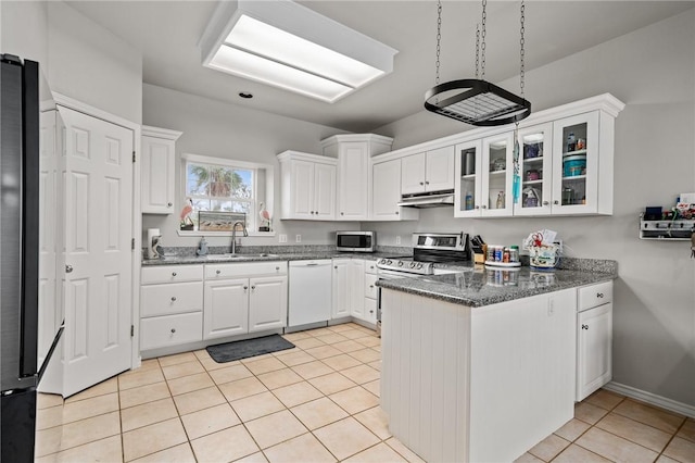 kitchen with glass insert cabinets, stainless steel appliances, under cabinet range hood, white cabinetry, and a sink