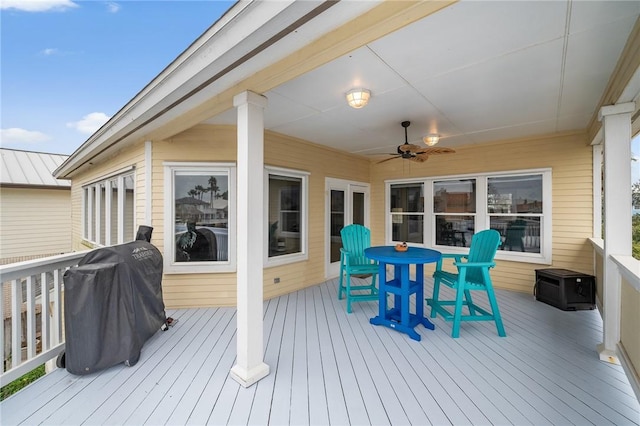 wooden deck featuring a ceiling fan, outdoor dining space, and grilling area