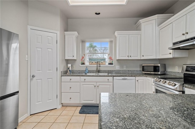 kitchen featuring light tile patterned floors, under cabinet range hood, a sink, white cabinets, and appliances with stainless steel finishes