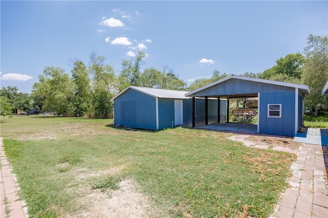 view of yard featuring a carport and an outdoor structure