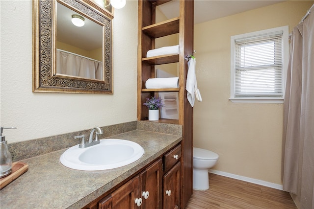 bathroom featuring vanity, toilet, and hardwood / wood-style floors