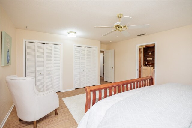 bedroom with multiple closets, ceiling fan, and light hardwood / wood-style flooring