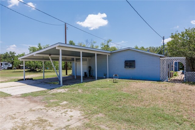 view of front of home with a front yard and a carport