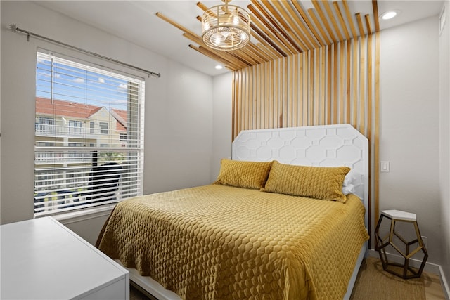 bedroom with ceiling fan with notable chandelier and multiple windows