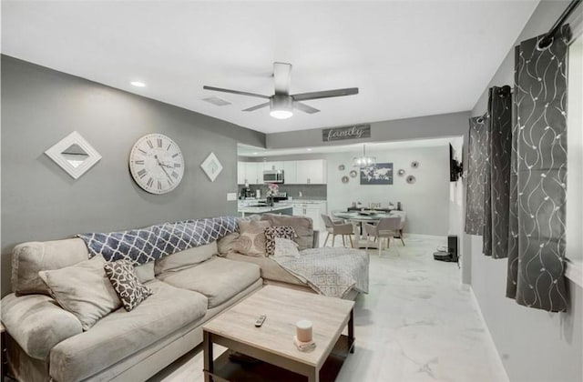 living room featuring ceiling fan with notable chandelier