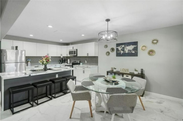 dining space with an inviting chandelier and sink