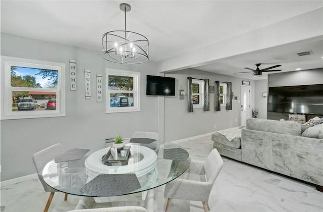 dining space featuring a healthy amount of sunlight and ceiling fan with notable chandelier