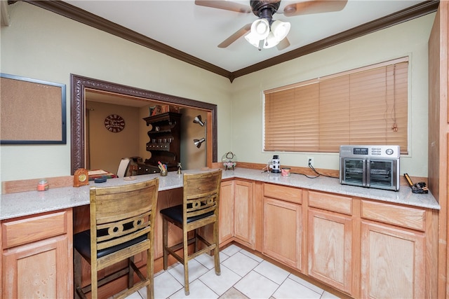 kitchen featuring light brown cabinetry, ceiling fan, light tile patterned floors, and ornamental molding