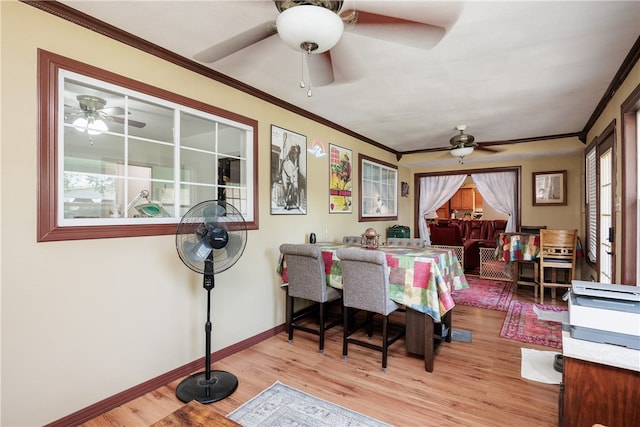 dining space with ornamental molding and light hardwood / wood-style flooring