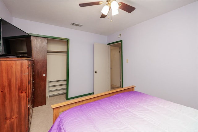 carpeted bedroom featuring ceiling fan and a closet