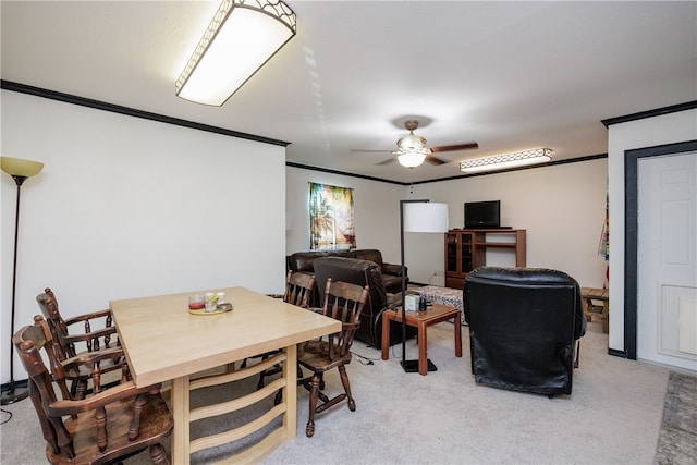 carpeted dining space with ornamental molding and ceiling fan