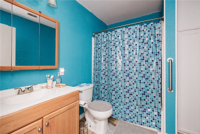 bathroom with tile patterned floors, toilet, curtained shower, a textured ceiling, and vanity