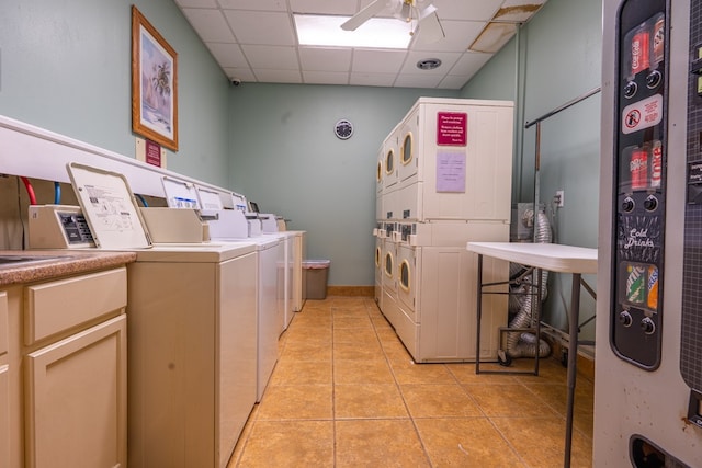 washroom featuring stacked washer and dryer, washing machine and dryer, light tile patterned floors, and ceiling fan