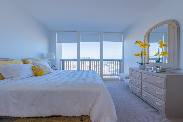 bedroom with access to outside, light colored carpet, and floor to ceiling windows