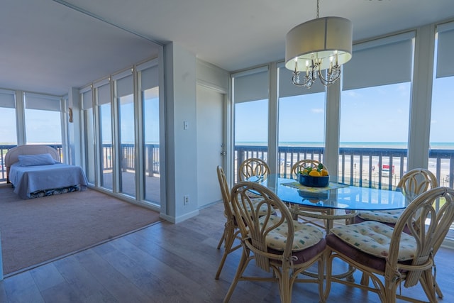 sunroom / solarium with an inviting chandelier, a healthy amount of sunlight, and a water view