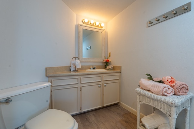 bathroom with toilet, vanity, lofted ceiling, and wood-type flooring