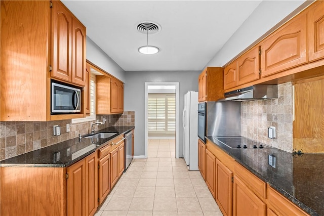 kitchen with light tile patterned floors, visible vents, black appliances, under cabinet range hood, and a sink