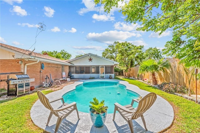 view of swimming pool with a sunroom, a fenced backyard, grilling area, a patio area, and a fenced in pool