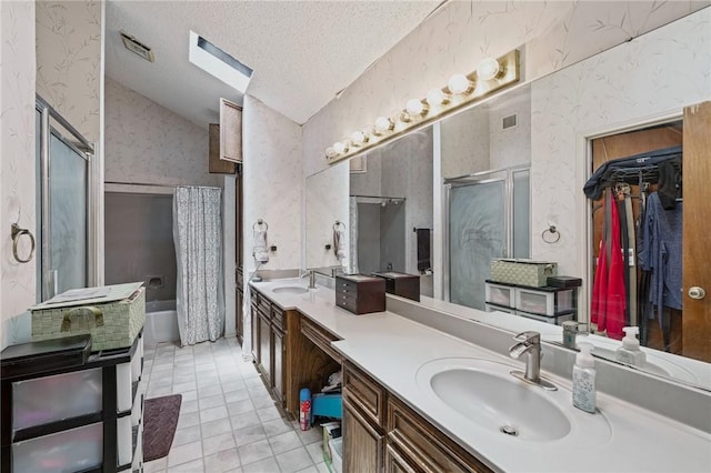 6906 Whalen Dr, Corpus Christi, TX 78413 - bathroom featuring wallpapered walls, double vanity, a stall shower, vaulted ceiling, and a walk in closet
