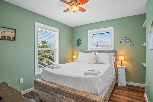 bedroom with multiple windows, ceiling fan, and dark hardwood / wood-style floors