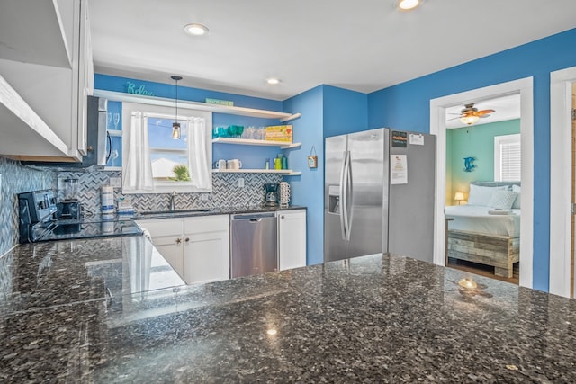 kitchen with white cabinets, ceiling fan, backsplash, appliances with stainless steel finishes, and decorative light fixtures