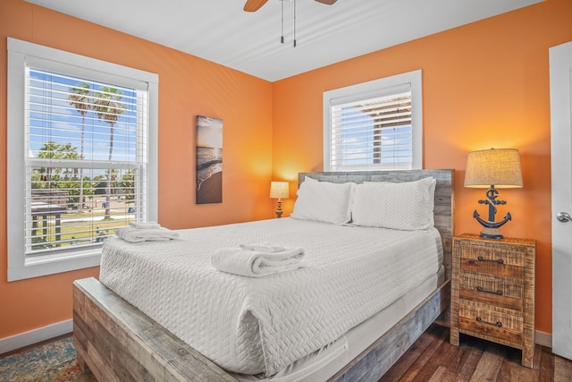 bedroom with dark wood-type flooring, multiple windows, and ceiling fan