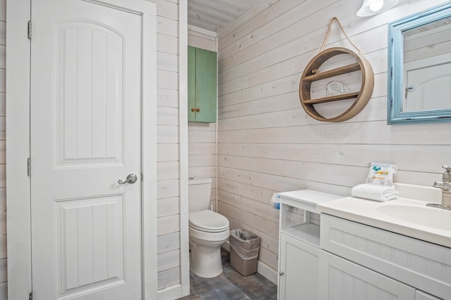 bathroom featuring hardwood / wood-style floors, wood walls, toilet, and vanity