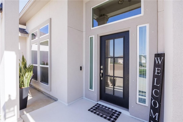 view of exterior entry featuring stucco siding