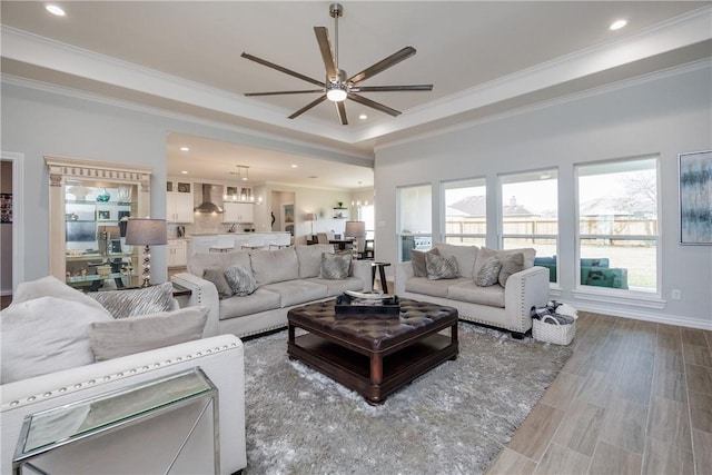 living area featuring a healthy amount of sunlight, ornamental molding, wood finished floors, and recessed lighting