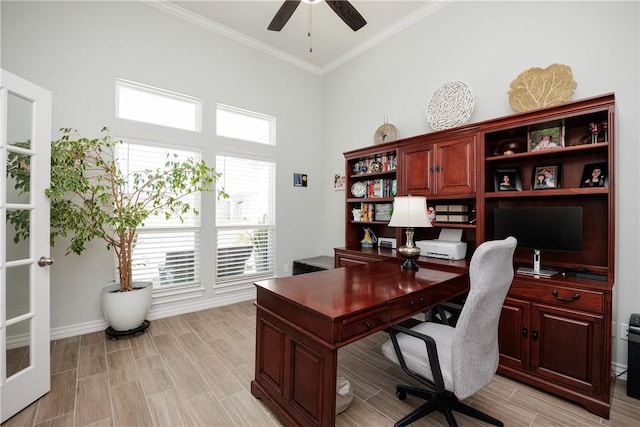 home office featuring wood finish floors, crown molding, a high ceiling, ceiling fan, and baseboards