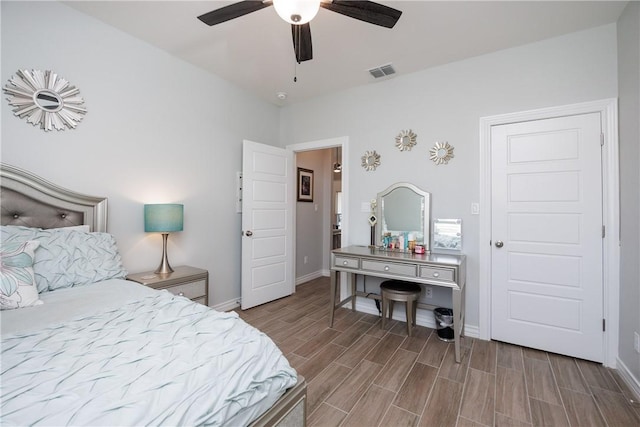 bedroom featuring wood finish floors, visible vents, ceiling fan, and baseboards