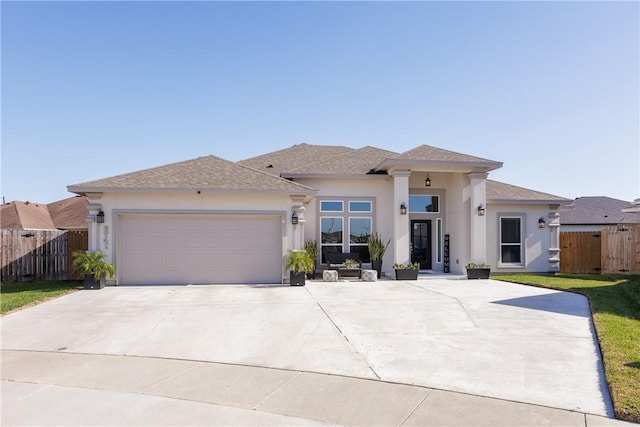 prairie-style home with roof with shingles, stucco siding, an attached garage, fence, and driveway