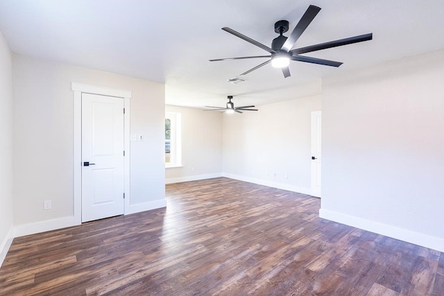 spare room with a ceiling fan, baseboards, visible vents, and wood finished floors