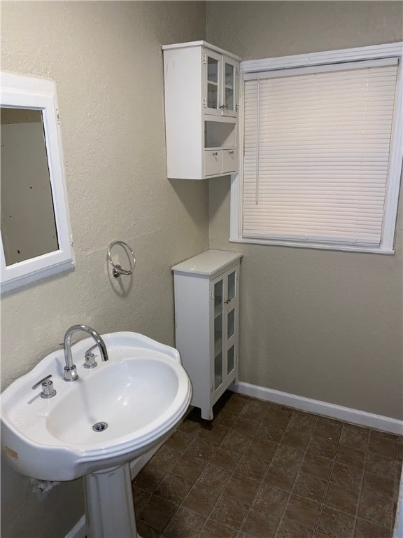 bathroom with a sink and baseboards