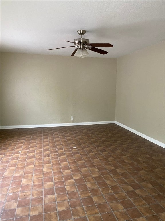 empty room with a ceiling fan and baseboards