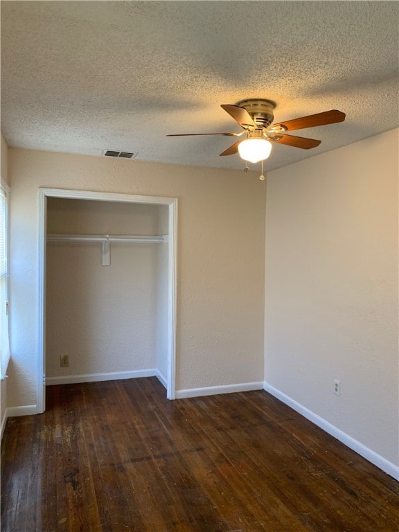 unfurnished bedroom featuring a ceiling fan, a closet, baseboards, and hardwood / wood-style floors