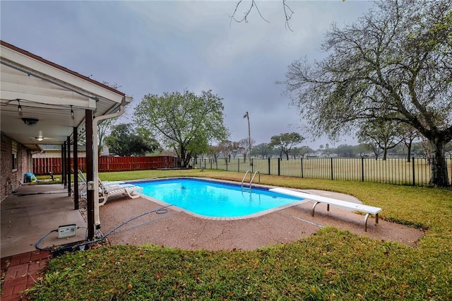 view of pool featuring a patio, a diving board, and a yard