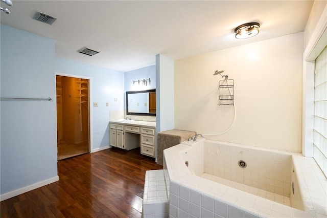 bathroom featuring vanity, hardwood / wood-style floors, and tiled bath