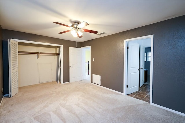 unfurnished bedroom with a closet, ceiling fan, and carpet