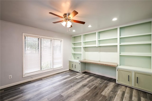 unfurnished office featuring dark wood-type flooring, ceiling fan, and a healthy amount of sunlight