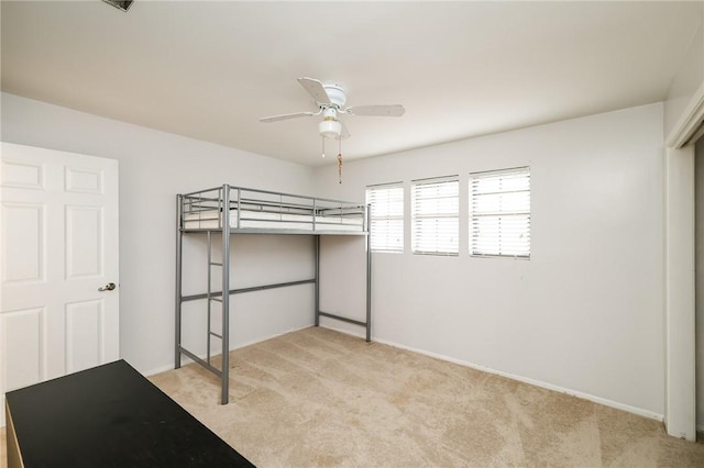 unfurnished bedroom featuring ceiling fan and light carpet